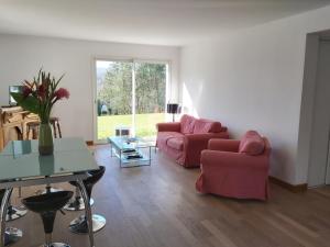 una sala de estar con 2 sofás rojos y una mesa. en Appartement Ascain, 3 pièces, 4 personnes - FR-1-239-504, en Ascain