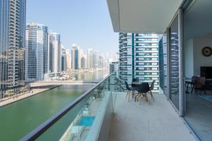 a balcony with a view of a river and buildings at Vacay Lettings - Waterfront Luxury home with full Marina view in Dubai