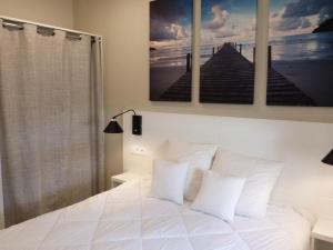 a bedroom with a white bed with two pillows at Appartement pour 4 pers avec terrasse, jardin, piscine et accès plage - Animaux admis - FR-1-194-218 in La Tranche-sur-Mer