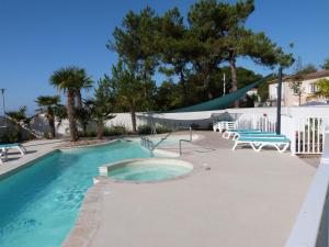 a swimming pool with two chairs and a swing at Appartement pour 4 pers avec terrasse, jardin, piscine et accès plage - Animaux admis - FR-1-194-218 in La Tranche-sur-Mer +13 photos