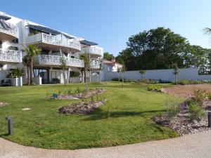 a yard in front of a building with trees at Appartement La Tranche-sur-Mer, 2 pièces, 4 personnes - FR-1-194-218 in La Tranche-sur-Mer