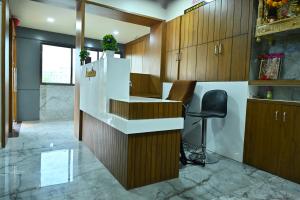 a kitchen with a counter and a stool at HOTEL SURY VILLA in Ahmedabad