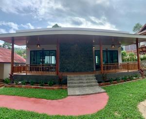 una casa con porche y escaleras en un patio en Nice Beach Resort Koh Pha-ngan en Thong Nai Pan Yai