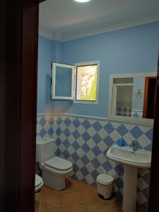a bathroom with a toilet and a sink at Casa Rocío&Paloma in Los Romanes
