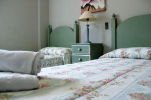 a bedroom with two beds and a table with a lamp at Casa Rocío&Paloma in Los Romanes