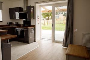 a kitchen with an open door to a yard at House of Juniper - Luxury Accessible Apartment in Broadford