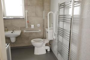 a bathroom with a toilet and a sink at House of Juniper - Luxury Accessible Apartment in Broadford