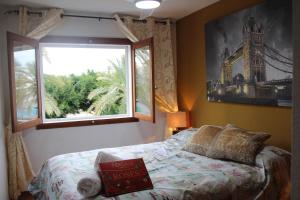 a bedroom with a window and a bed with a book at CASA ISA BEACH, 1 minute to the beach in Puebla de Farnals