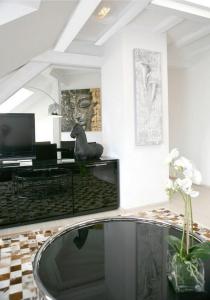 a living room with a glass table and a tv at VISIONAPARTMENTS Cramerstrasse 8-12 - contactless check-in in Zurich