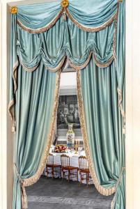 una sala da pranzo con tavolo e tenda blu di No Other Place - Palazzo Storico a Vicenza