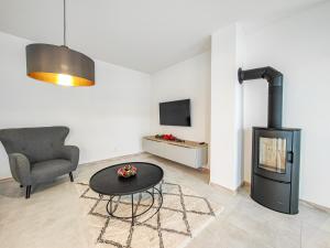 a living room with a fireplace and a chair at Chalets New Apartmány Ivachnová in Ivachnová