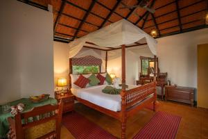 a bedroom with a large bed with a canopy at Vythiri Mist Resort in Vythiri