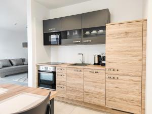 a kitchen with wooden cabinets and a table at Chalets New Apartmány Ivachnová in Ivachnová