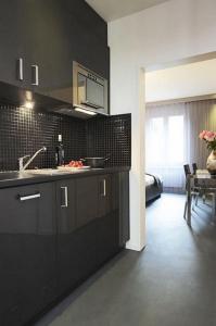a kitchen with black cabinets and a dining room at VISIONAPARTMENTS Cramerstrasse 8-12 - contactless check-in in Zürich
