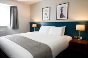 a hotel room with a large bed and two lamps at The Caledonian Hotel in Leven-Fife