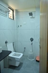 a white bathroom with a toilet and a sink at HOTEL SURY VILLA in Ahmedabad +27 photos