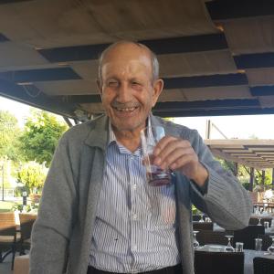 a man is smiling while holding a glass at Hadrian Gate Hotel in Antalya