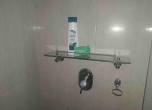 a glass shelf in a bathroom with a bottle of toothpaste at Acogedor y amplio apartamento perfecta ubicacion! in Bogotá