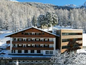 ein Gebäude im Schnee mit schneebedeckten Bäumen in der Unterkunft Hotel Mignon in Sulden