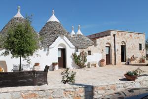 a building with a courtyard with chairs and a tree at Fontana Vecchia B&B in Castellana Grotte