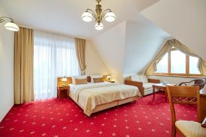 sypialnia z dużym łóżkiem i czerwonym dywanem w obiekcie Hotel Burkaty w mieście Białka Tatrzanska