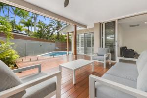 an open living room with a view of a swimming pool at Key Ct 10 in Noosa Heads