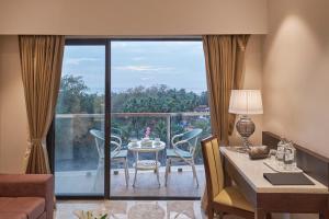 a living room with a table and chairs on a balcony at Regenta Central Imperial Candolim Goa in Candolim