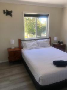 a bedroom with a large bed and a window at Branxton Baybrook Apartment in Branxton