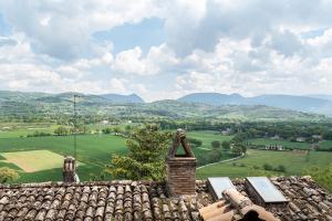 a roof of a house with mountains in the background at City Center Apartments - Happy Rentals in Spello