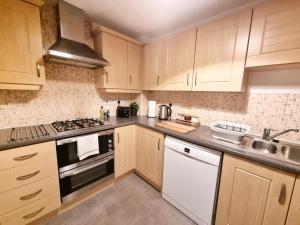 a kitchen with white appliances and wooden cabinets at Modern & Spacious 3 bedrooms and 2 bathrooms Home, Free Parking! in Cambridge