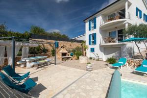 a patio with chairs and a swimming pool and a house at Apartments Villa Padrone with pool - perfect for families! in Garica