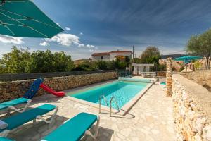 a swimming pool with chairs and an umbrella at Apartments Villa Padrone with pool - perfect for families! in Garica