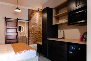 a kitchen with a sink and a brick wall at Oxford on Otho in Inverell