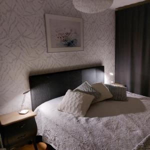 ein Schlafzimmer mit einem Bett und einem Tisch mit einer Lampe in der Unterkunft Blue River in Rovaniemi