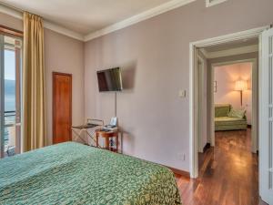 una habitación de hotel con una cama y un televisor en Villa Cappellina, en Toscolano Maderno