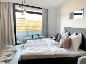 ein großes Bett in einem Schlafzimmer mit einem großen Fenster in der Unterkunft ✪ Beautiful Studio in Center with Amazing View ✪ in Mannheim