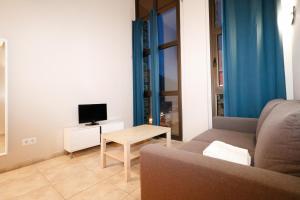 a living room with a couch and a tv and a table at Apartamentos Degas MIKKA 3000 in El Tarter
