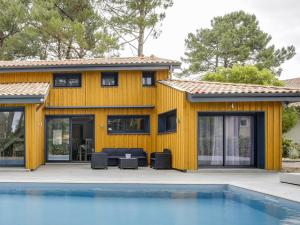 a yellow house with a pool in front of it at Villa 5 chambres à Biscarrosse avec piscine chauffée, wifi, proche océan - FR-1-521-18 in Biscarrosse-Plage