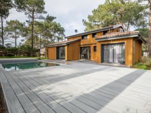 a house with a swimming pool in front of a house at Villa 5 chambres à Biscarrosse avec piscine chauffée, wifi, proche océan - FR-1-521-18 in Biscarrosse-Plage