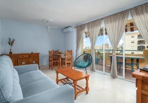 ein Wohnzimmer mit einem blauen Sofa und einem Tisch in der Unterkunft Aldea de Sabinilla in San Luis de Sabinillas