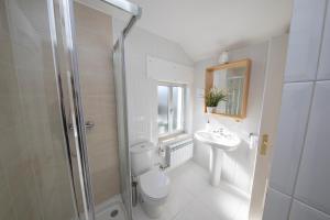 a bathroom with a toilet and a sink and a shower at Apartagal- Casa Playa, Foz in Foz +49 photos