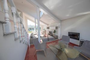 uma sala de estar com sofás e cadeiras e uma lareira em Apartagal- Casa Playa, Foz em Foz