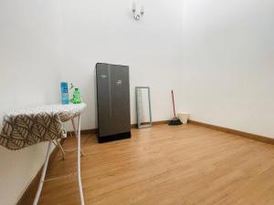 a room with a refrigerator and a wooden floor at Homestay 3BR near Setia Alam in Shah Alam