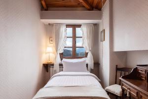 Arachova Wooden Chalet في أراخوفا: غرفة نوم بسرير ونافذة