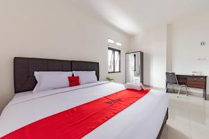 Un dormitorio con una cama grande con una manta roja. en RedDoorz @ Suryakencana Bogor en Bogor
