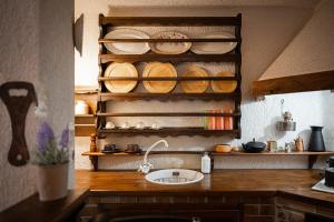 a kitchen with a sink and shelves with dishes at Arachova Wooden Chalet in Arachova