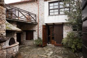 a stone house with a wooden door and a balcony at Arachova Wooden Chalet in Arachova