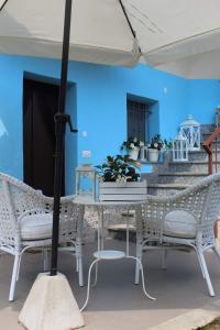 een tafel en stoelen onder een parasol op een patio bij Albero della vita in Cuneo