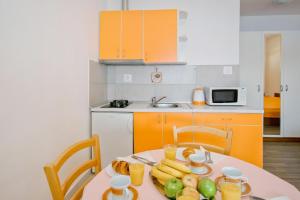 eine Küche mit einem Tisch und einem Obstteller darauf in der Unterkunft Apartments Ane in Molunat