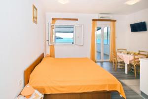 a bedroom with a bed with an orange bedspread at Apartments Ane in Molunat